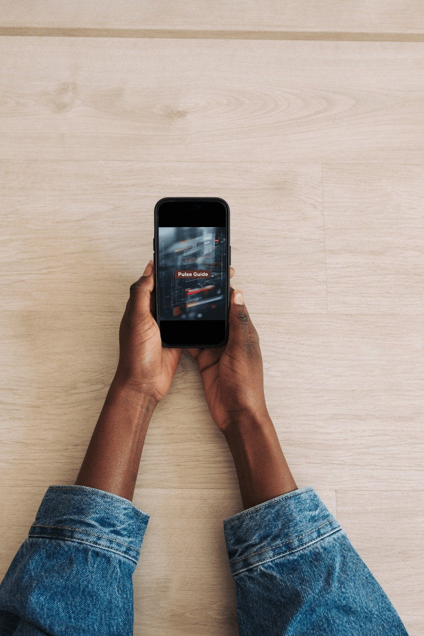 Person holding a smartphone with a game app on a wooden surface